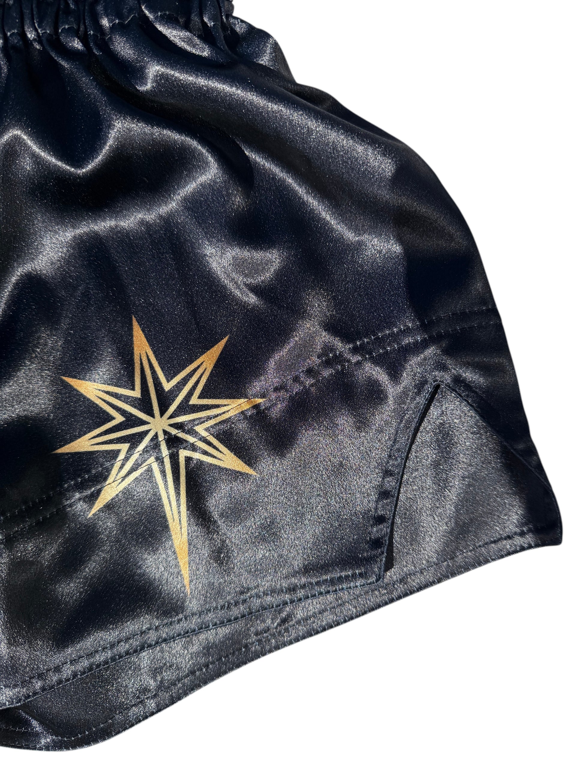 Lodestar Muay Thai shorts in black polyester with a gold star graphic and side slits for enhanced movement.
